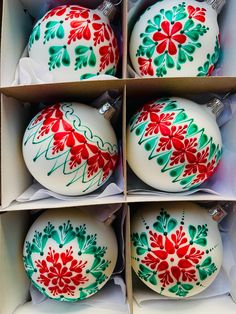 four christmas ornaments in boxes with red and green designs