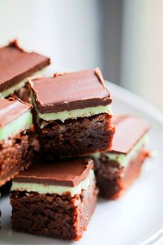 several pieces of chocolate cake sitting on top of a white plate