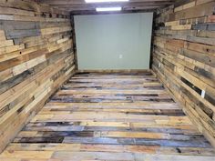 an empty room with wood flooring and walls made out of pallet boards on the wall