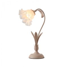 a lamp that is sitting on top of a white stand with a light bulb in the shape of a flower