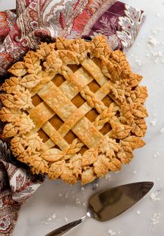 a pie sitting on top of a table next to a knife and fork with salt scattered around it