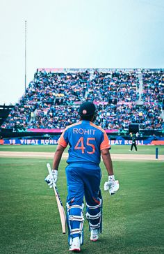 a man walking across a baseball field holding a bat and wearing catcher's gear