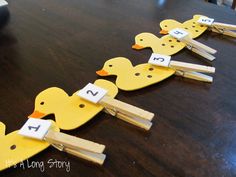 ducks are lined up on clothes pins to spell out the letter h with letters in them