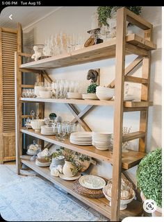 a wooden shelf filled with dishes and glasses