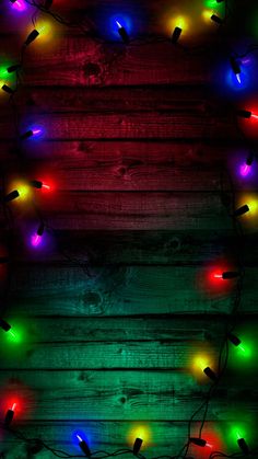 christmas lights on wooden planks with red, green and blue lights in the middle