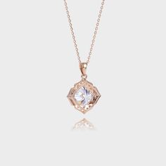 a gold necklace with a white diamond in the center