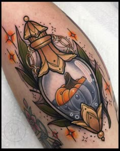 a tattoo with an image of a fish in a glass jar on the arm and leaves around it