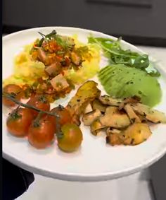 a white plate topped with lots of different types of food on top of a table