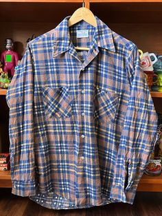 "This is a vintage 1970s Plaid Flannel Shirt that features a collar with long points, making it more stylish. The plaid pattern combines warm and cool looks! The texture of vintage flannel is notably more comfortable compared to modern versions. As depicted, three out of five buttonholes have minor tears around them, which do not impact the functionality and can be easily repaired. This shirt is an excellent choice for the fall season! While it's approximately a men's medium in size, I recommend referencing the following measurements before making a purchase, as all sales are considered final. Measurements in inches: Shoulder seam to shoulder seam: 16 7/8\" Armpit to armpit: 20 1/2\" Shoulder seam to cuff: 24 1/4\" Length (top of shoulder to hem): 30\" Since all sales are final, please fee Retro Button-up Flannel Shirt, Retro Collared Flannel Shirt, Vintage Long Sleeve Flannel Shirt, Vintage Long Sleeve Winter Shirt, Retro Plaid Button-up Flannel Shirt, Retro Button-up Winter Shirt, Vintage Plaid Cotton Shirt, Vintage Shirt With Spread Collar For Fall, Retro Collared Flannel Shirt For Winter