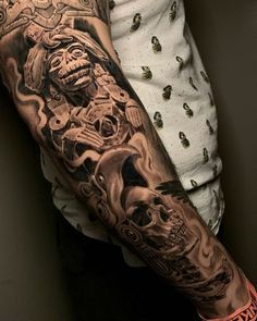 a man's arm with tattoos on it and an image of a skull in the middle