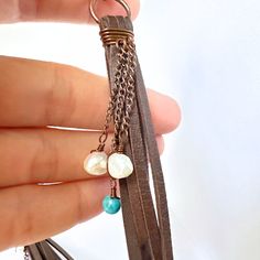 Introducing these stunning handmade leather tassel earrings, carefully wrapped in copper wire on a copper ring for that boho-chic touch. Each earring is beautifully accented with charming turquoise beads, up cycled pearls, and delicate copper chain details. These earrings are a perfect blend of rustic charm and elegant style, making them a unique addition to your jewelry collection. Elevate your look with these one-of-a-kind statement earrings that are sure to turn heads wherever you go. Bohemian Brown Copper Wire Jewelry, Hand Wrapped Brown Dangle Jewelry, Bohemian Hand Wrapped Brown Earrings, Bohemian Brown Hand Wrapped Earrings, Bohemian Brown Hand-wrapped Earrings, Artisan Brown Jewelry With Tassels, Leather Tassel Earrings, Copper Ring, Copper Rings