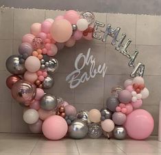 the balloon arch is decorated with pink, grey and white balloons that spell out baby