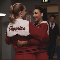 two women in cheerleader outfits hugging each other