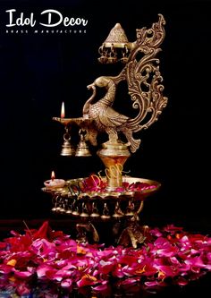 an elaborately decorated fountain with candles and petals on the ground in front of it