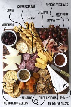 a wooden board topped with different types of cheese and crackers