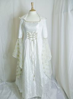 a white dress on a mannequin with laces around the waist and sleeves