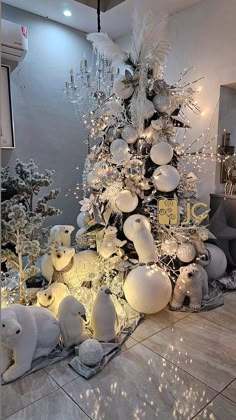 a christmas tree with white ornaments and lights in the shape of polar bears is shown