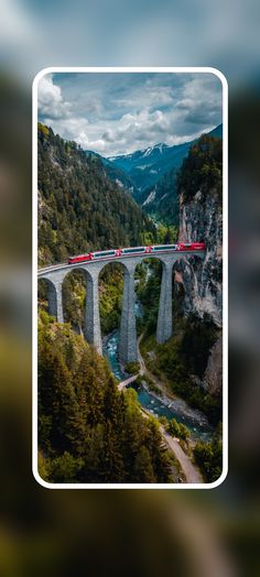 a long bridge over a river next to a lush green forest