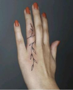 a woman's hand with a small tattoo on it