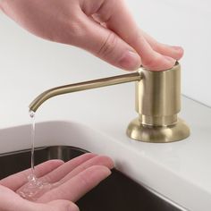 a person is washing their hands under a faucet