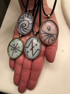 three pendants on a person's hand