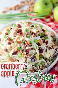 an apple and cranberry coleslaw salad in a white bowl on a red checkered tablecloth