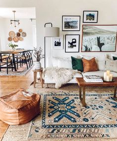 a living room filled with lots of furniture and pictures on the wall above it's coffee table