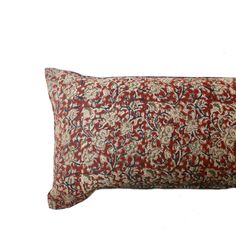 a red and blue pillow with an intricate design on the front, sitting against a white background