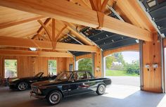 two cars are parked in a garage with wood paneling on the walls and ceiling