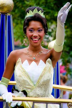 a woman in a princess costume waves to the crowd