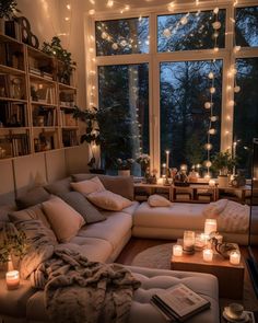 a living room filled with lots of furniture and candles in front of a large window