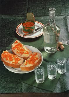 there is a plate with bread and glasses on the table next to bottles of water