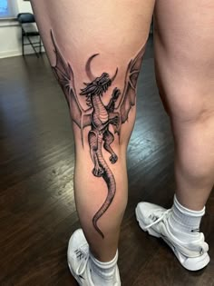 a woman's leg with a dragon tattoo on it