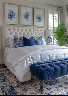 a bedroom with blue and white decor on the walls, an upholstered bed, and two windows