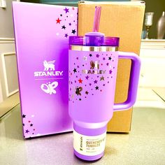 a purple travel mug next to a pink box with the lid open and straw in it