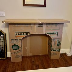 an open cardboard box sitting on top of a hard wood floor next to a mirror