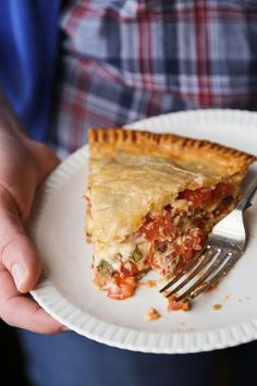 a person holding a plate with a piece of pie on it