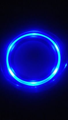 a neon blue glow ring on a black background with the light reflecting off it's surface