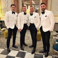 three men in white tuxedos standing next to each other on a checkered floor