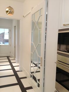 an empty kitchen with black and white flooring