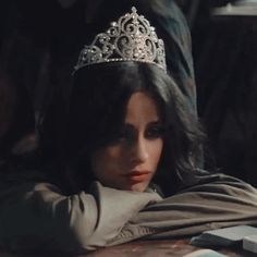 a woman wearing a tiara sitting at a table