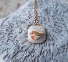 .: Robin ceramic pendant necklace :. LAST ONE ready to ship!   Give a cute gift to someone you love or just adorn yourself with something really unique!  The pendant is made of earthenware clay and glazed with rustic glazes. The pendant have been fired two times, finally at 1940 F (1060 C). Each product is handmade which makes my jewelry unique. Handmade, glazed and fired in my home studio. This pendant is available: ¤ 18" (45cm)  24k gold plated dainty necklace ¤ 18" (45cm) sterling silver necklace I ship all the orders with a registered airmail. Please note that shipping depends on many factors and sometimes might take longer than stated in the shop policies. Shipping to USA, Canada takes about 2-4 weeks Shipping to Australia takes 4-5 weeks Shipping to Europe takes usually 1-2 weeks Ceramic Pendant Necklace, Jewelry Ceramic, Pottery Jewelry, Ceramic Glazes, Robin Bird, Bird Necklace, Bird Pendant, Earthenware Clay, Rustic Jewelry