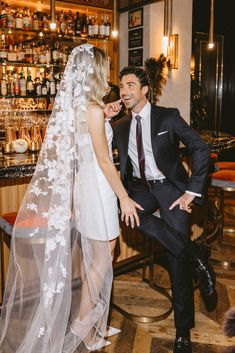 a bride and groom sitting at a bar