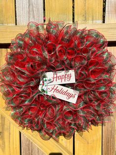 a red wreath with the words happy holidays on it