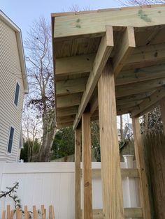 a wooden structure sitting next to a white fence