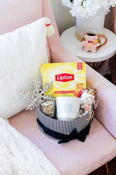 a pink chair sitting next to a white table with a cup on top of it