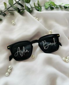 two sunglasses with the word'anohn'written on them sitting on a white sheet