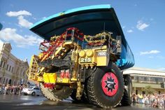 a large dump truck parked in front of a crowd