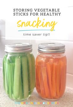 two jars filled with pickles and carrots sitting on top of a kitchen counter