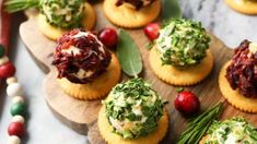 small appetizers are arranged on wooden boards with green garnish and cranberry toppings